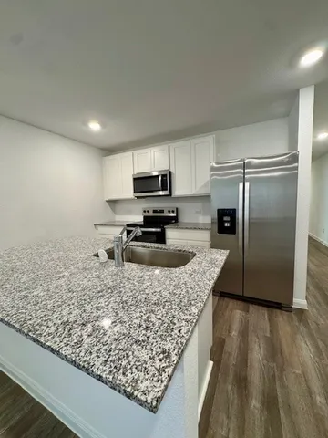 an empty room with wooden floor & bathroom