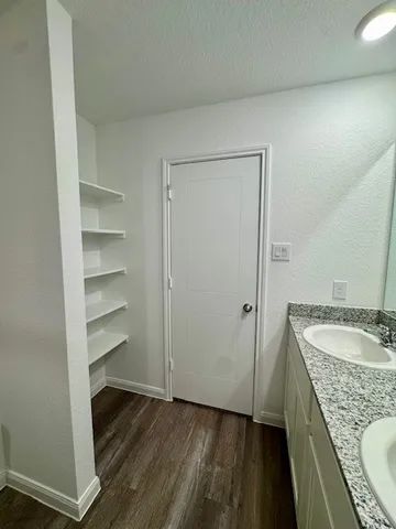 a bathroom with a granite countertop sink a toilet a mirror and a tub
