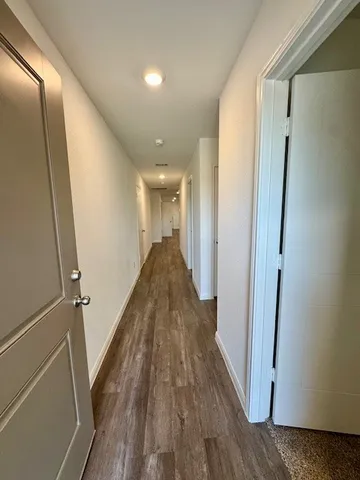 a view of a hallway with wooden floor and staircase