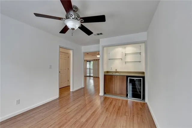a view of a kitchen with a stove wooden floor a ceiling fan and wooden floor
