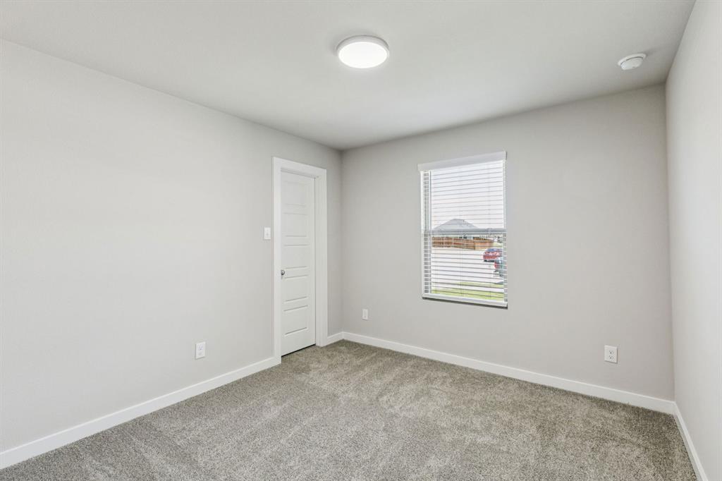 7804 Kingfisher Road Aubrey, TX 76227 - Photo 18 of 27 an empty room with a window and a bathroom