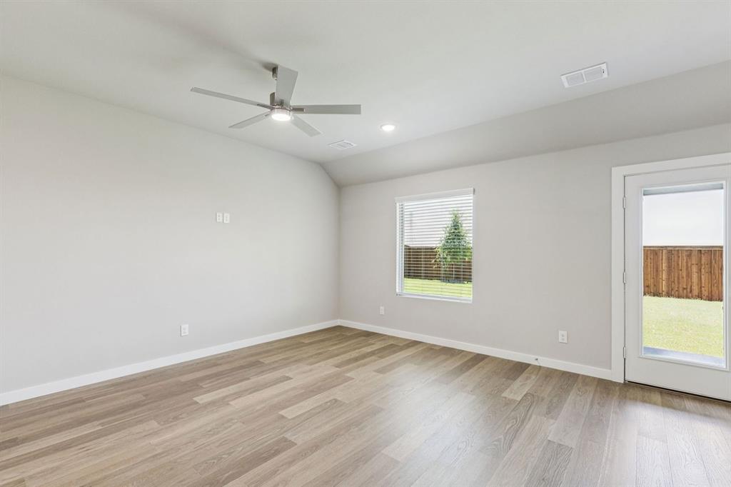 7804 Kingfisher Road Aubrey, TX 76227 - Photo 8 of 27 an empty room with wooden floor fan and windows