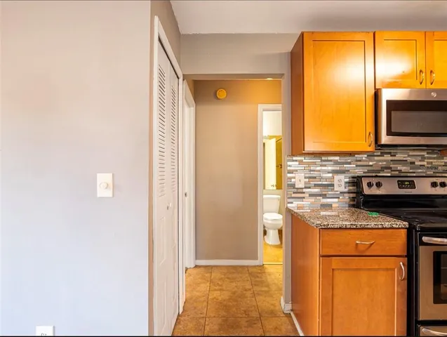 a kitchen with stainless steel appliances granite countertop a stove a sink and a refrigerator with wooden floor