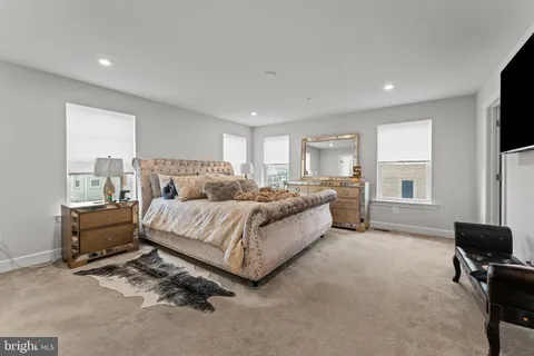 a spacious bedroom with a bed a couch and large window