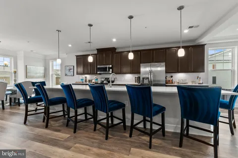 a kitchen with a dining table chairs and white cabinets