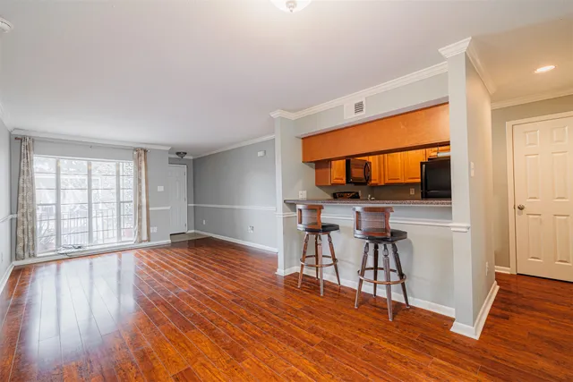 a view of empty room with wooden floor and furniture