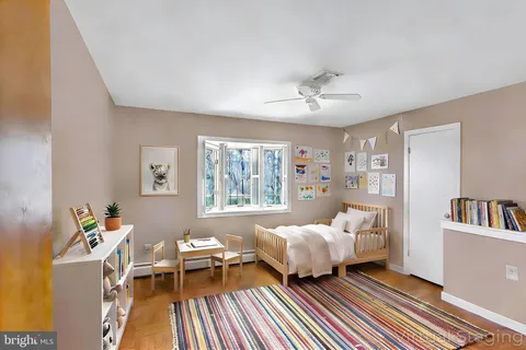 a living room with baby crib furniture a window and a chandelier