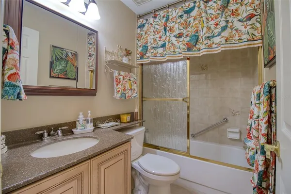 a bathroom with a granite countertop sink mirror toilet and shower