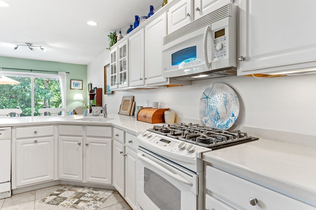 1 Prestwick Road, Unit 1 Bourne, MA 02532 - Photo 13 of 31 a kitchen with stainless steel appliances granite countertop white cabinets and window