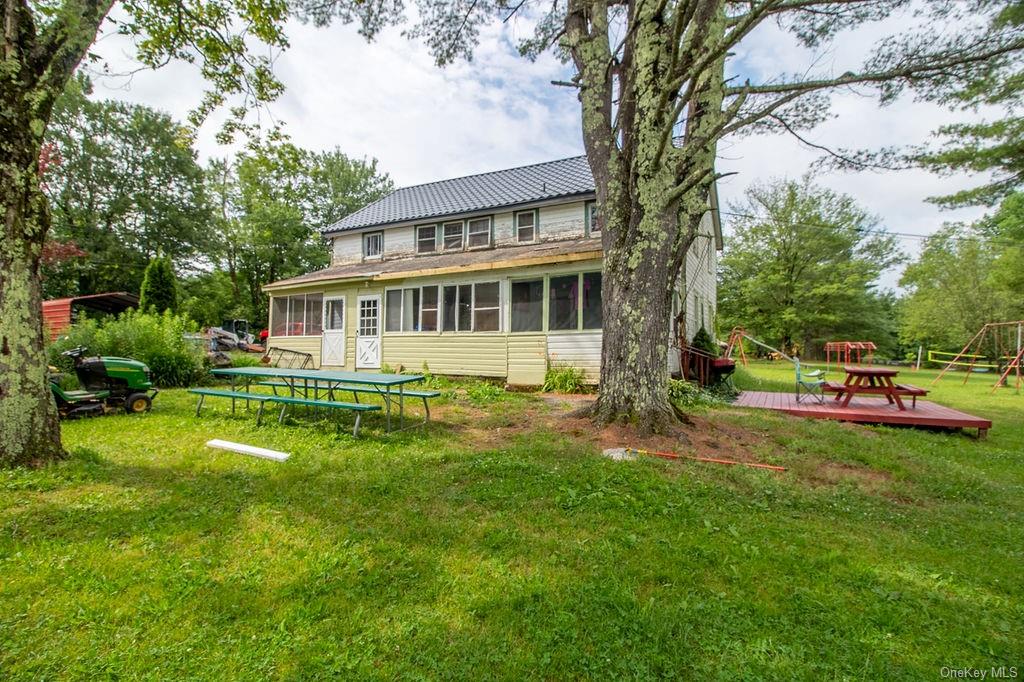 1105 Ulster Heights Road Ellenville, NY 12428 - Photo 11 of 36 Back of house featuring a sunroom, a wooden deck, a trampoline, and a lawn