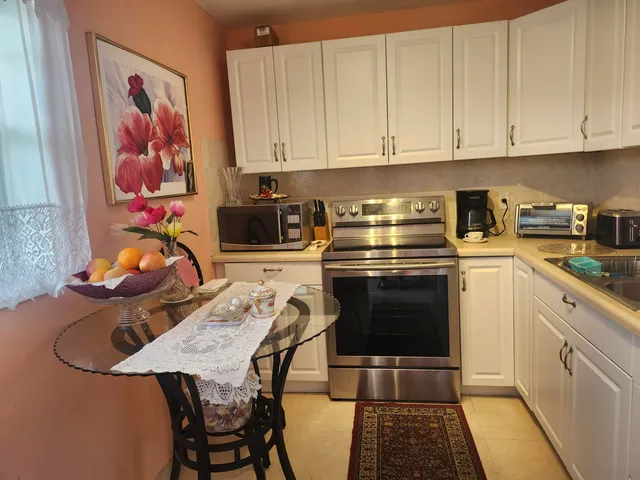 a kitchen with stainless steel appliances granite countertop a stove and white cabinets