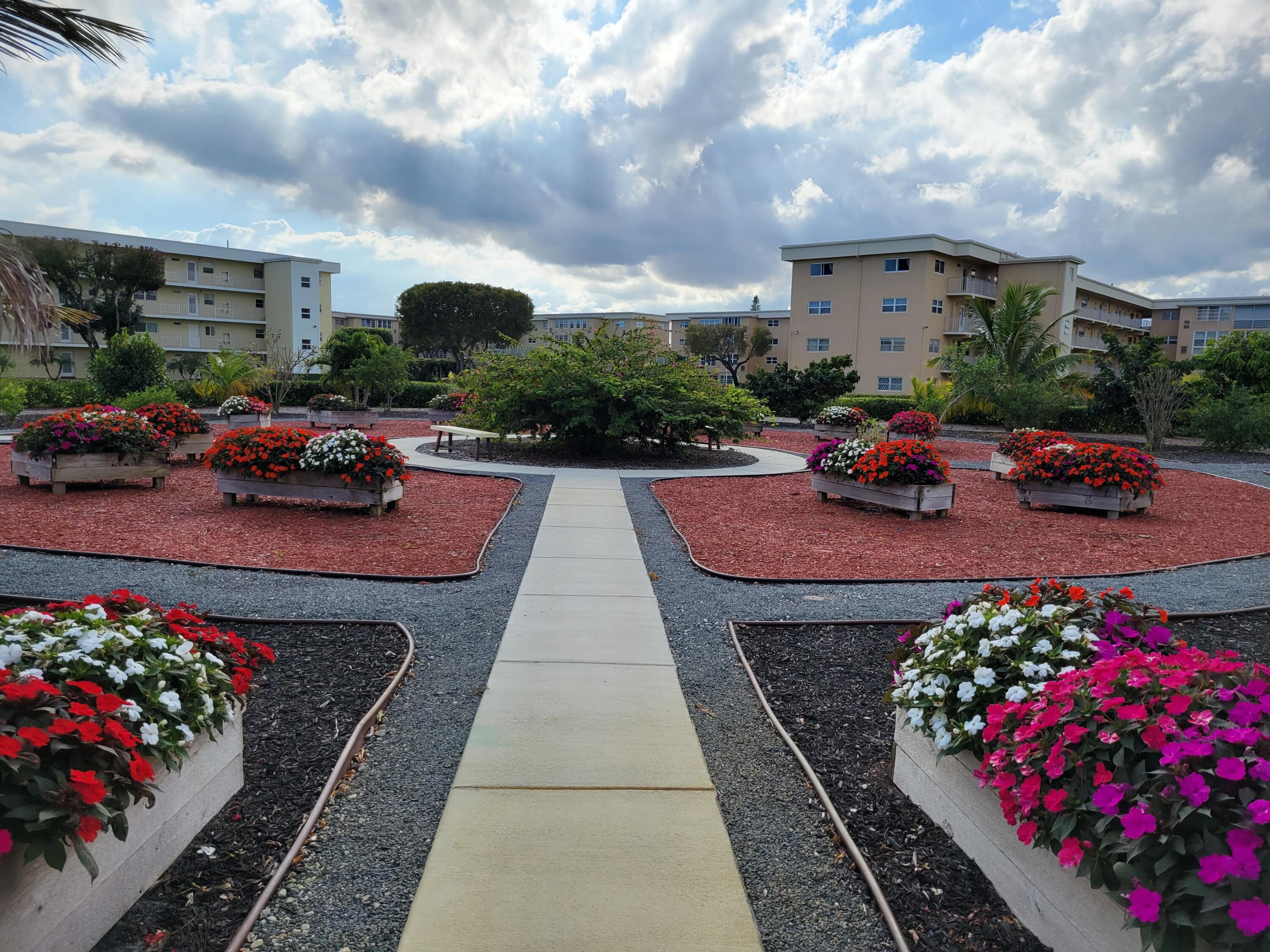 2400 Northeast 1st Lane, Unit 206 Boynton Beach, FL 33435 - Photo 28 of 32 a view of a patio with a table and chairs and potted plants