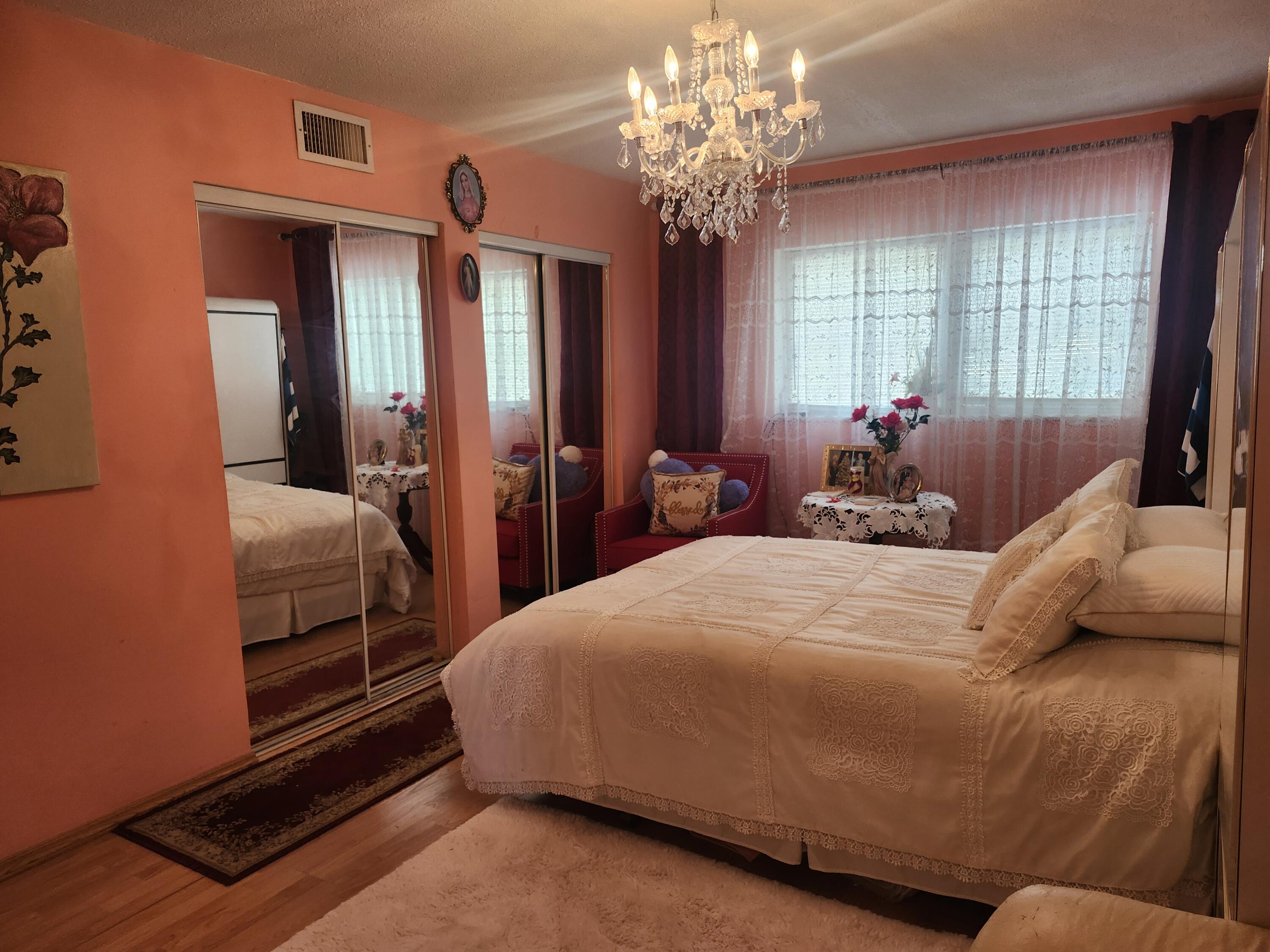 2400 Northeast 1st Lane, Unit 206 Boynton Beach, FL 33435 - Photo 3 of 32 a bedroom with a bed and a chandelier