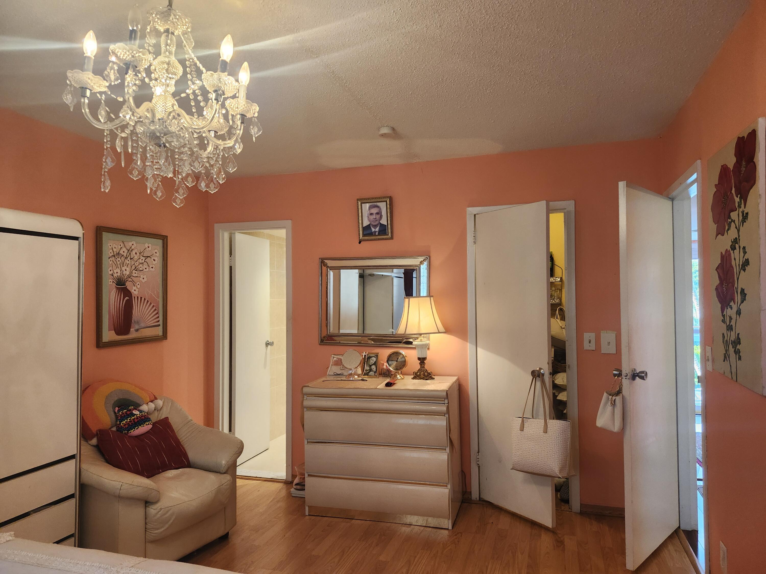 2400 Northeast 1st Lane, Unit 206 Boynton Beach, FL 33435 - Photo 5 of 32 a living room with furniture and a chandelier