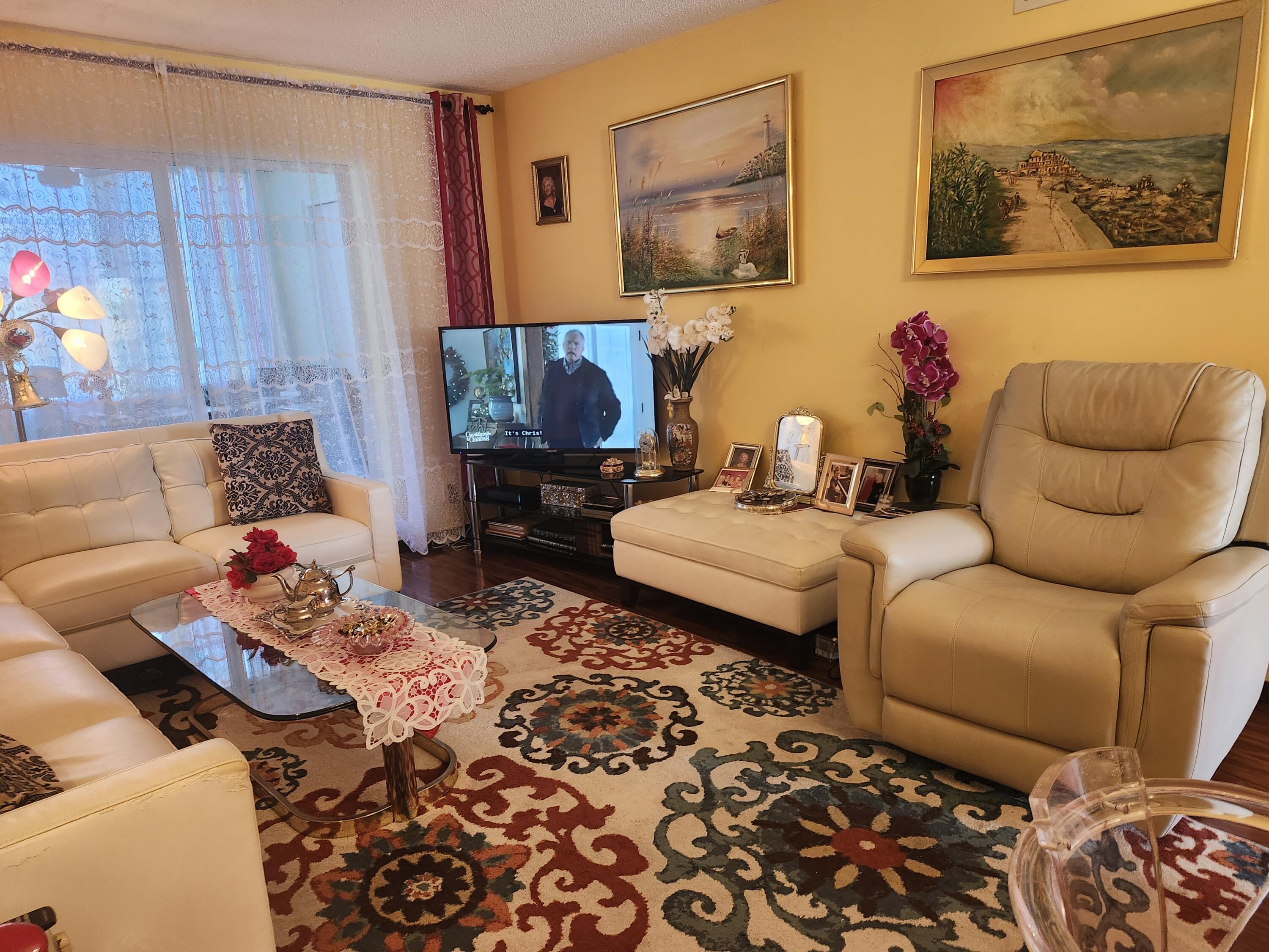 2400 Northeast 1st Lane, Unit 206 Boynton Beach, FL 33435 - Photo 7 of 32 a living room with furniture and a flat screen tv