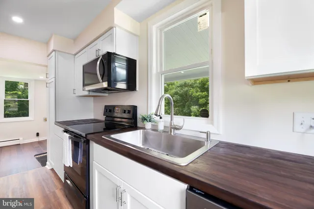 a kitchen with granite countertop a sink and a stove top oven