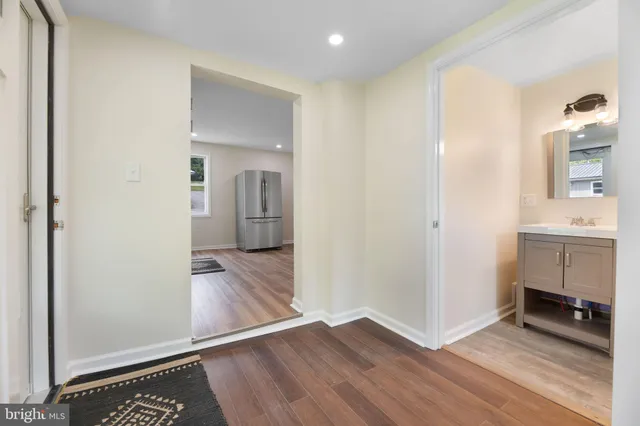 a view of hallway with sink and wooden floor