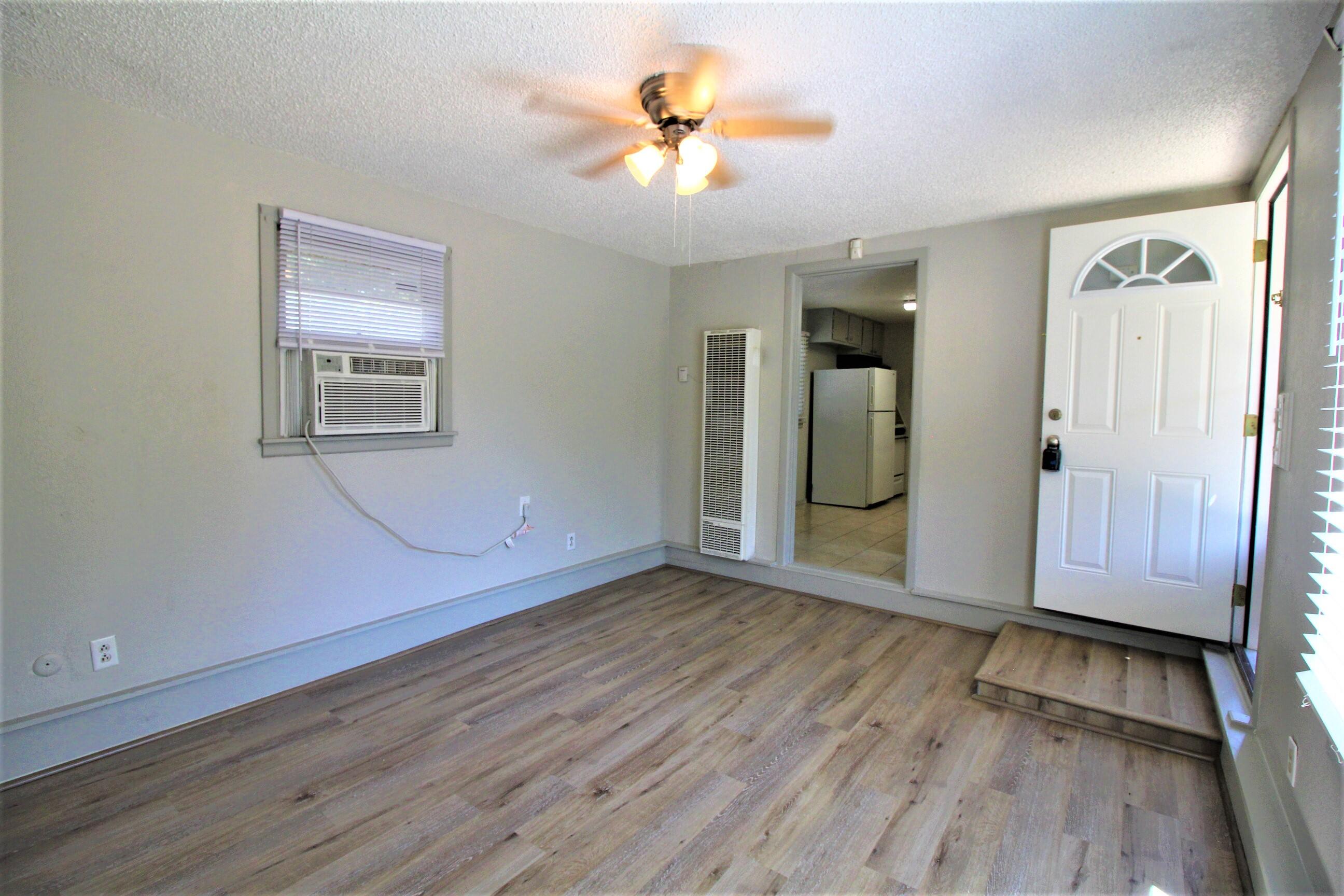 2216 30th Street Lubbock, TX 79411 - Photo 13 of 21 an empty room with wooden floor and a ceiling fan