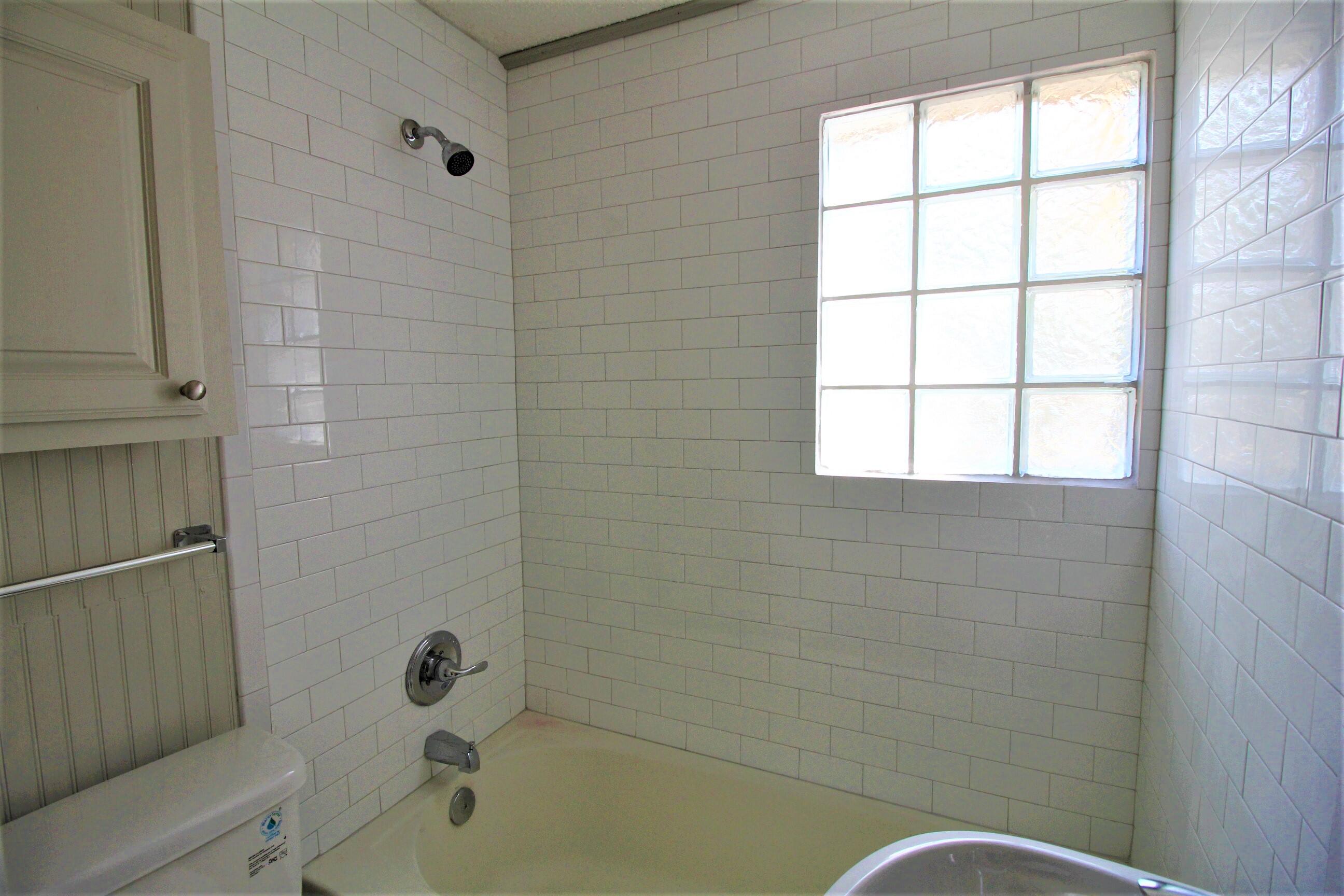 2216 30th Street Lubbock, TX 79411 - Photo 20 of 21 a bathroom with a bathtub and window