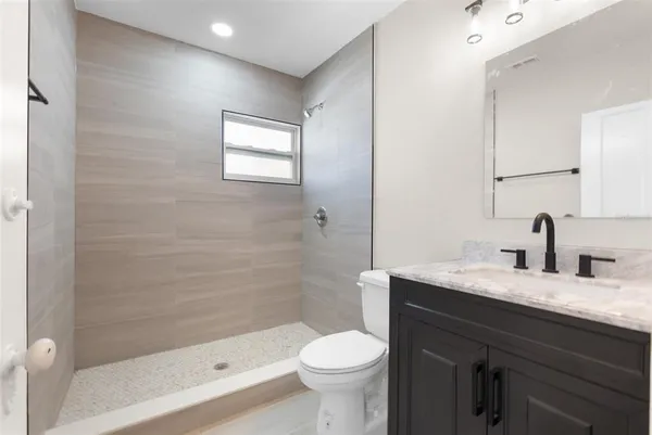 a bathroom with a granite countertop toilet sink and shower