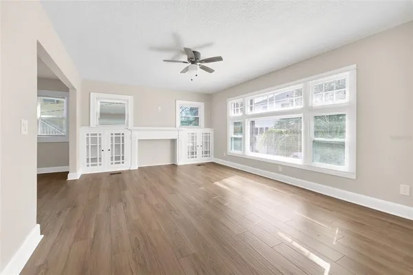 a view of an empty room with a window and wooden floor