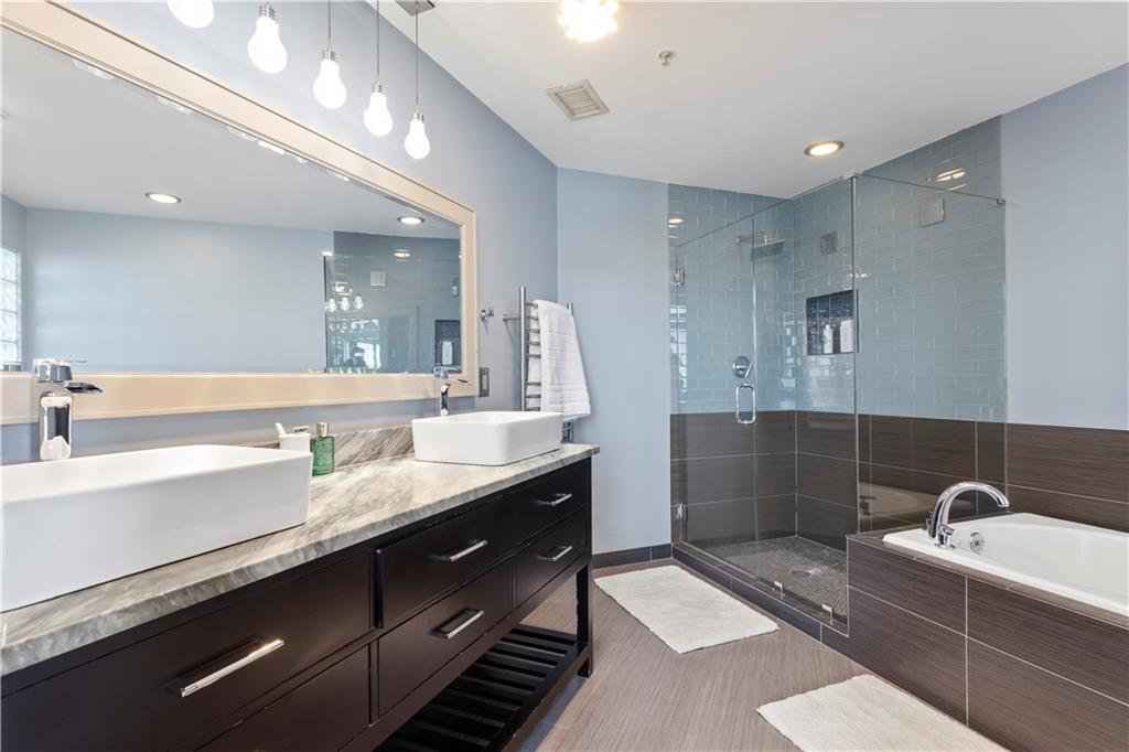 3180 Mathieson Drive Northeast, Unit 807 Atlanta, GA 30305 - Photo 12 of 22 a spacious bathroom with a granite countertop sink a toilet a mirror and bathtub