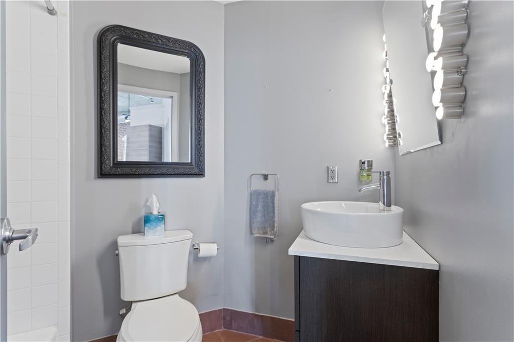 3180 Mathieson Drive Northeast, Unit 807 Atlanta, GA 30305 - Photo 14 of 22 a bathroom with a toilet sink and mirror