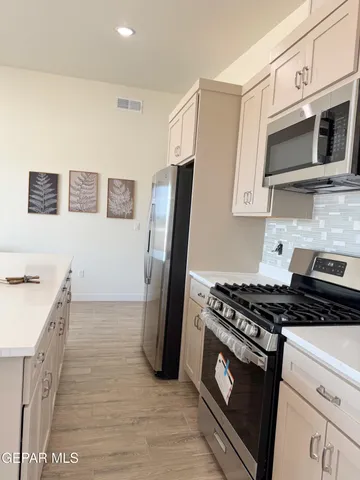 a kitchen with granite countertop a stove and a refrigerator
