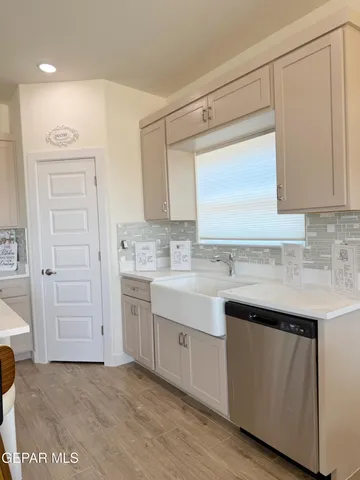 a kitchen with white cabinets and sink