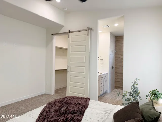 a bedroom with a bed and a potted plant