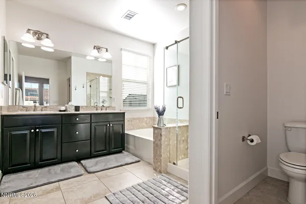 a spacious bathroom with a granite countertop sink a mirror and a toilet