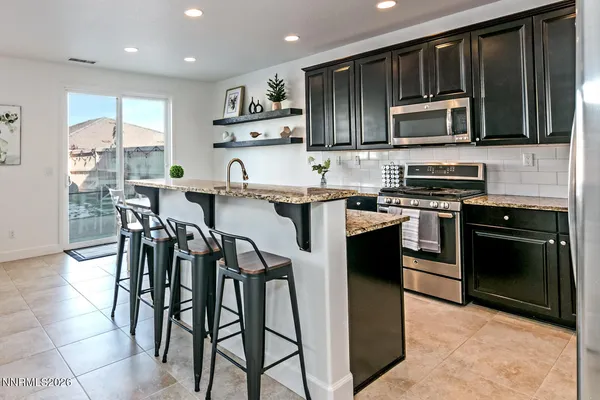 a kitchen with stainless steel appliances granite countertop wooden cabinets a stove top oven a sink and dishwasher