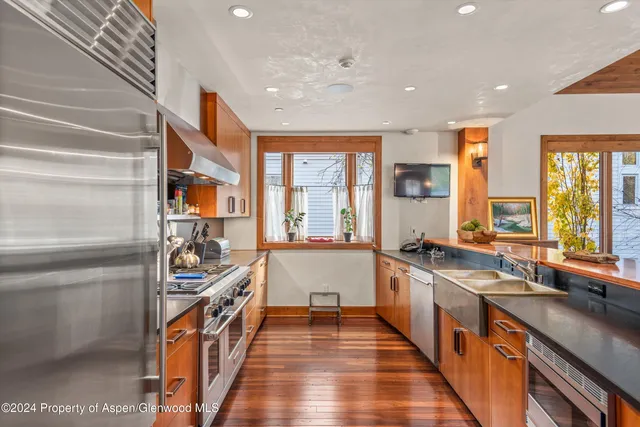 a view of a house with a tree and wooden fence