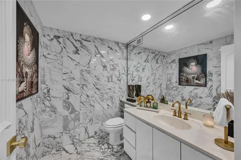 a bathroom with a sink toilet a mirror and shower curtain