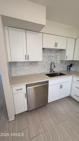 a kitchen with stainless steel appliances granite countertop a sink and a white cabinets