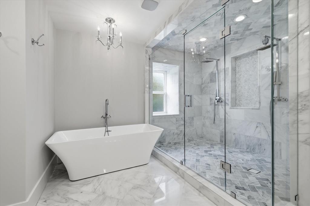 4310 Forest Bend Road Dallas, TX 75244 - Photo 20 of 40 Freestanding soaking tub with floor-mounted faucet, frameless glass shower enclosure, double shower heads, and marble tile flooring