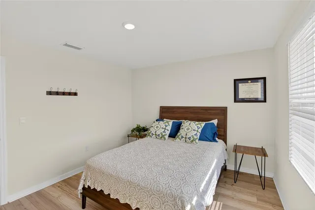 a bedroom with a bed and wooden floor