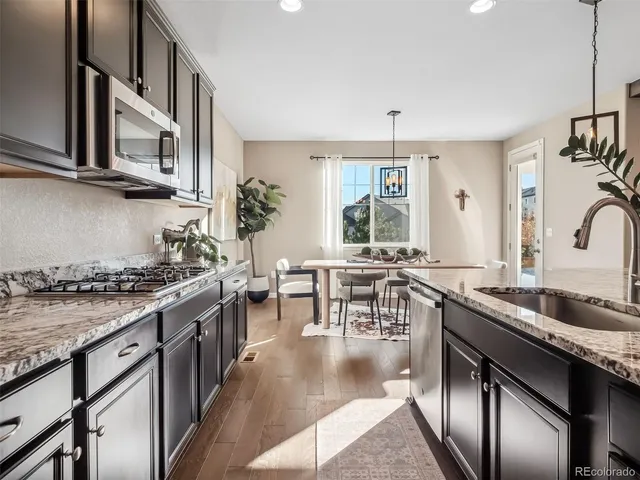 a kitchen with stainless steel appliances granite countertop a sink stove and cabinets