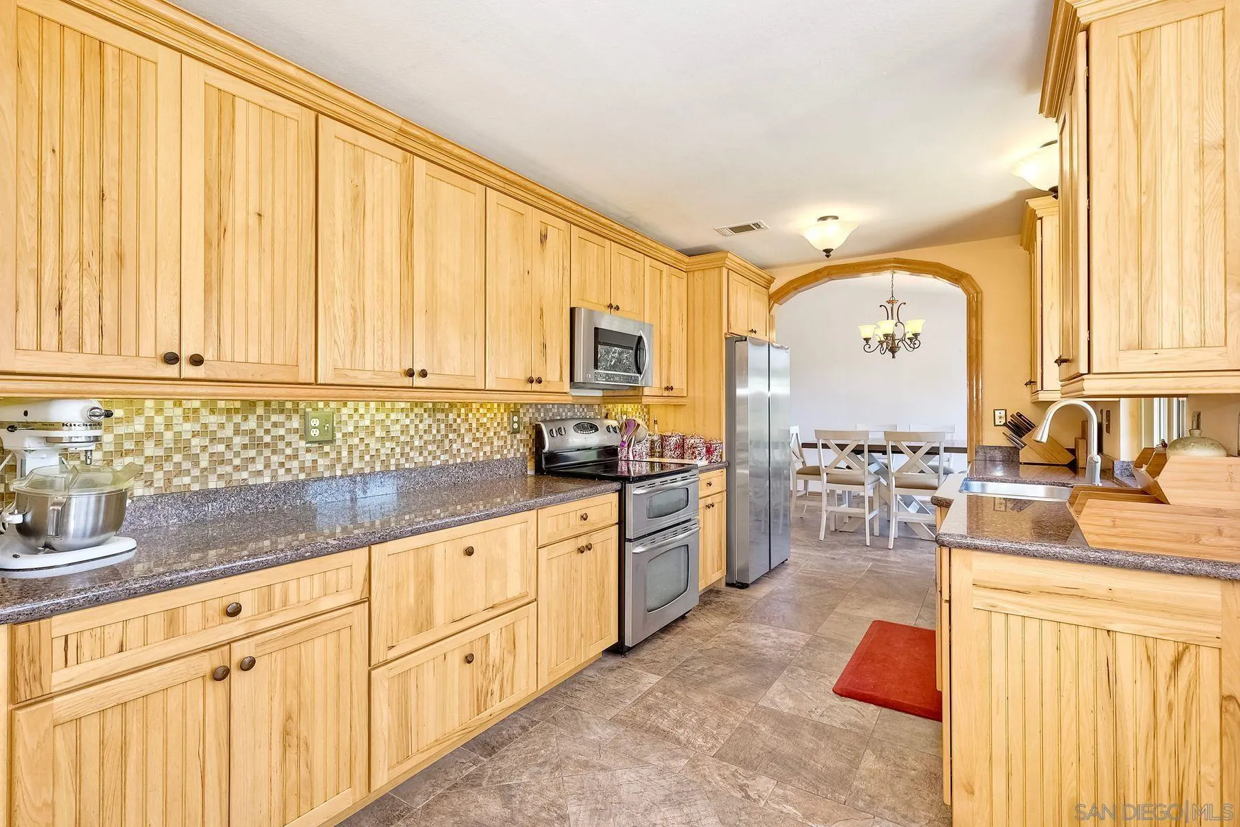 3805 Catamarca Drive San Diego, CA 92124 - Photo 12 of 59 a kitchen with stainless steel appliances granite countertop a sink dishwasher stove and refrigerator with wooden floor
