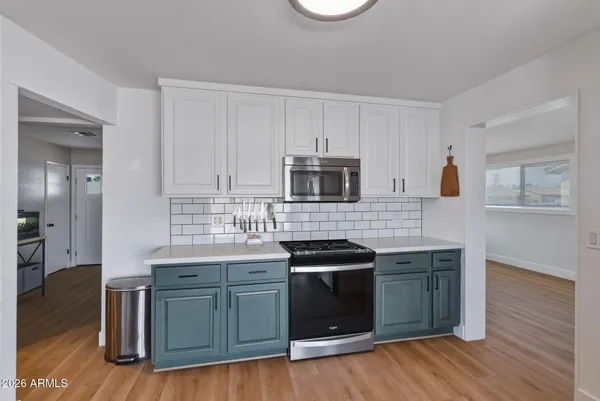 a kitchen with stainless steel appliances granite countertop a stove a sink and a microwave
