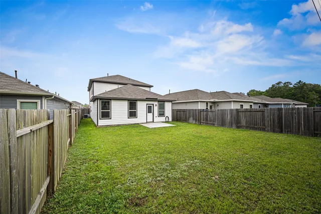 a view of a yard in front of a house with large trees