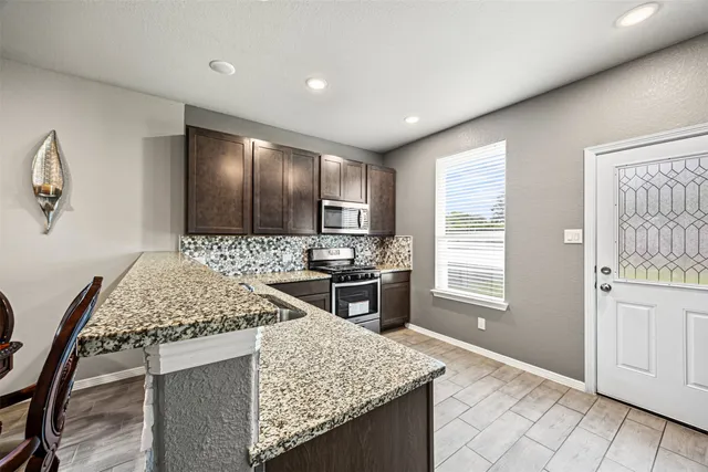 a kitchen with stainless steel appliances granite countertop a sink stove and refrigerator