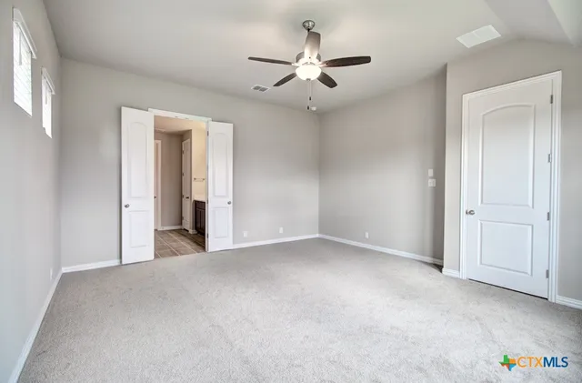 an empty room with a ceiling fan and a window