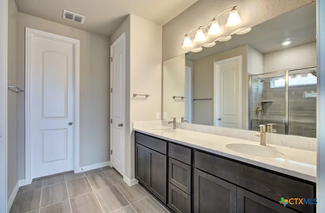 a bathroom with a sink double vanity and a mirror