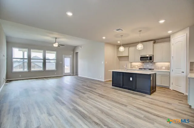 a kitchen with stainless steel appliances granite countertop a stove cabinets and wooden floor