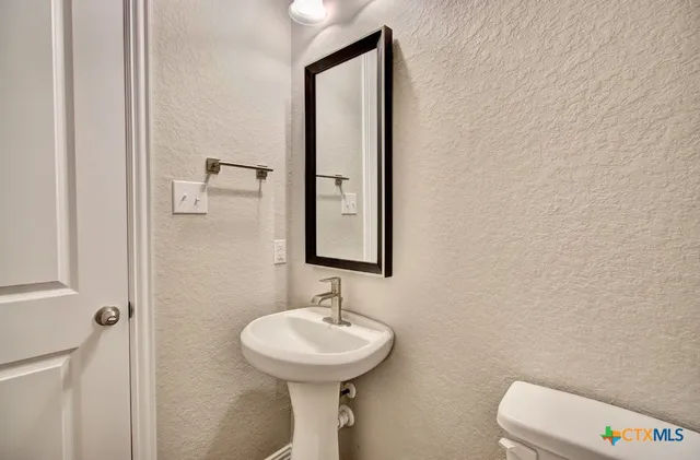 a bathroom with a sink a mirror and toilet
