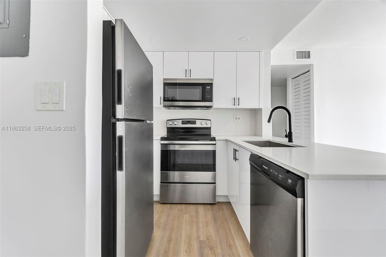 620 Southwest 10th Street, Unit 405 Miami, FL 33130 - Photo 2 of 21 a kitchen with a refrigerator sink and cabinets