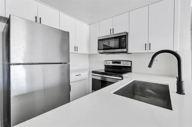 a kitchen with a refrigerator and a sink