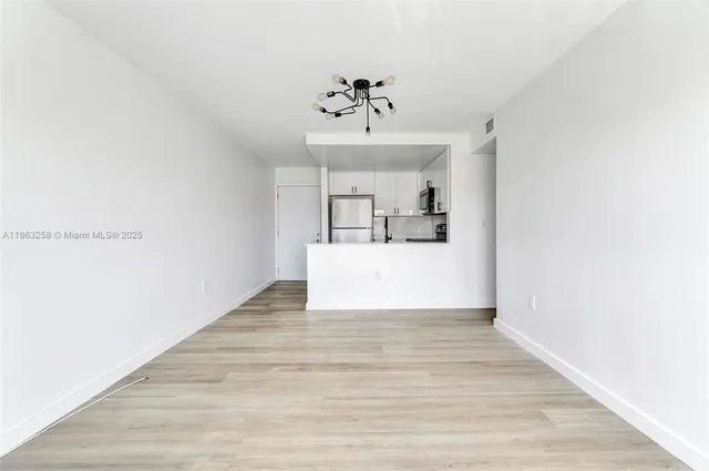 a view of a kitchen with wooden floor and ceiling fan