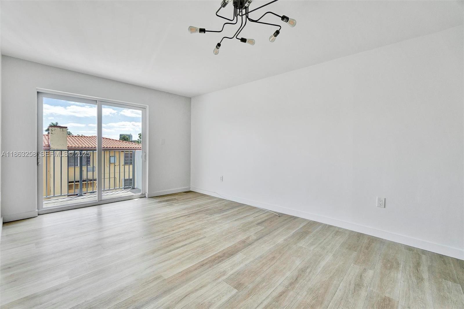 620 Southwest 10th Street, Unit 405 Miami, FL 33130 - Photo 5 of 21 wooden floor in an empty room with a window